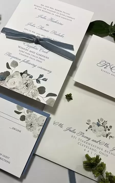 White floral print paired with dusty blue velvet ribbon and blue envelope. Two sided rsvp card.