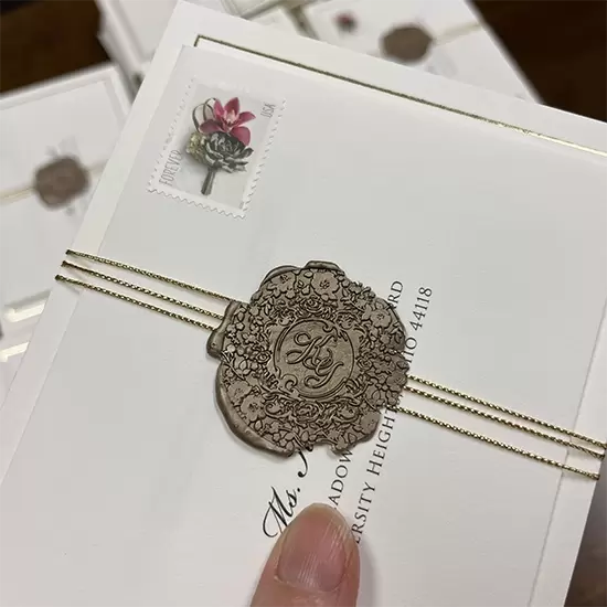 Katy's custom gold seal with gold string. Invitation with letterpress and gold foil.